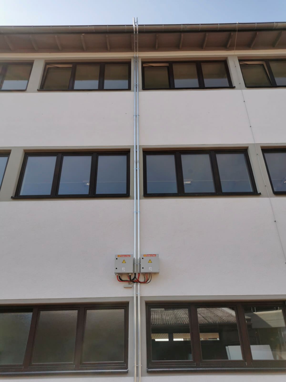 Außenansicht eines weißen Gebäudes mit mehreren Fensterreihen.