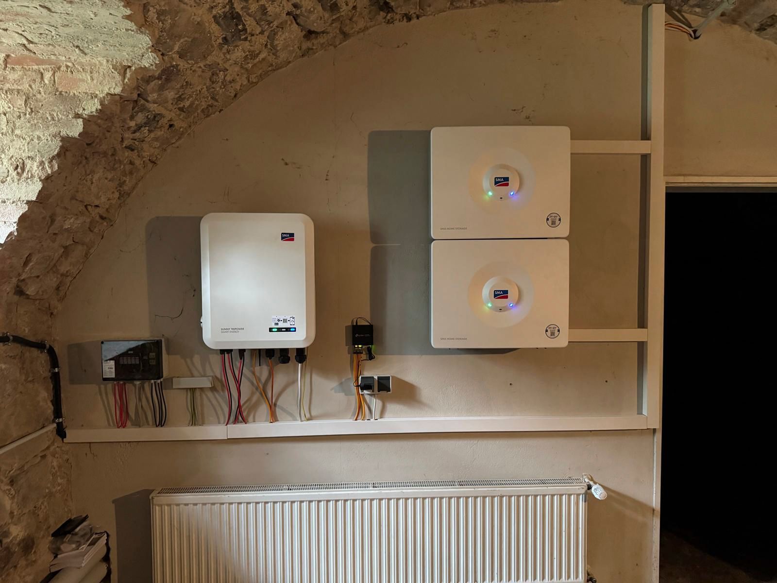 Solarwechselrichter und elektrische Komponenten zur Wandmontage. Inklusive weißer Gehäuse, Verkabelung und Heizkörper.