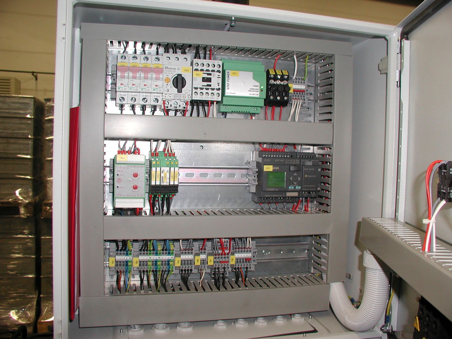 Elektrischer Schaltschrank mit verschiedenen Schaltern, Relais und Verkabelung.