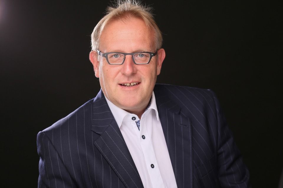 Rechtsanwalt Bernd Scheske - Ein Mann im Anzug und mit Brille lächelt in die Kamera.