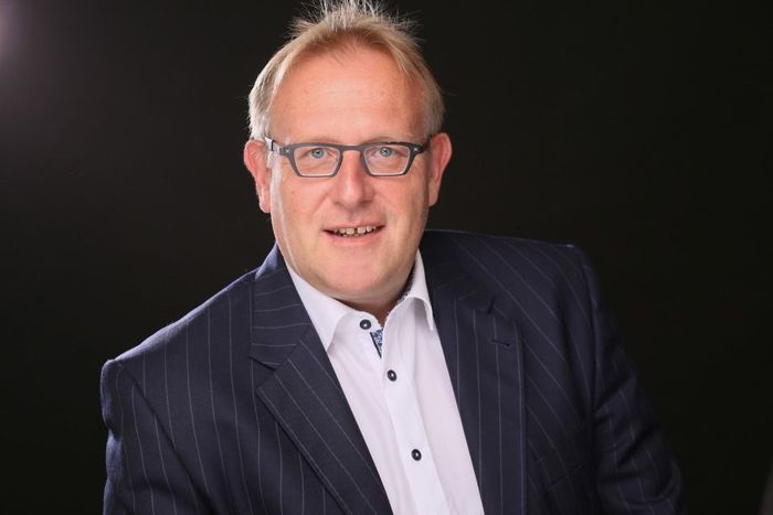 Rechtsanwalt Bernd Scheske - Ein Mann im Anzug und mit Brille lächelt in die Kamera.