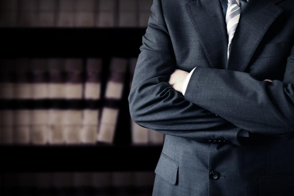 Rechtsanwalt Bernd Scheske - Ein Mann hält eine Waage der Gerechtigkeit über ein Klemmbrett.