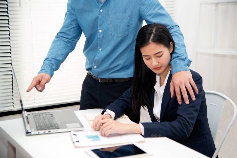 Rechtsanwalt Bernd Scheske - Ein Mann steht neben einer Frau, die mit einem Laptop an einem Schreibtisch sitzt.