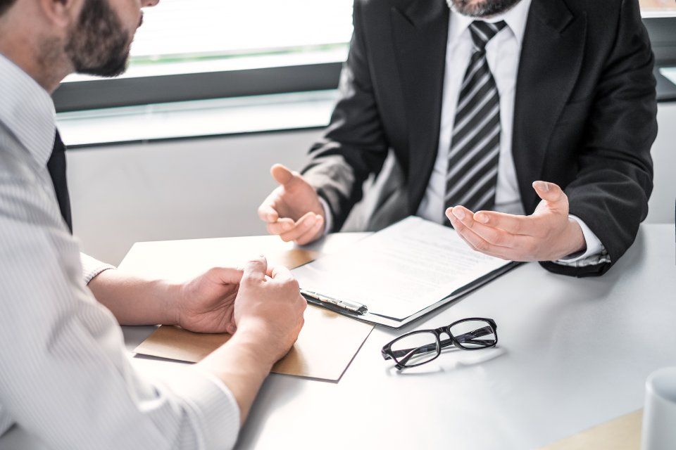 Rechtsanwalt Bernd Scheske - Zwei Männer sitzen an einem Tisch und unterhalten sich.