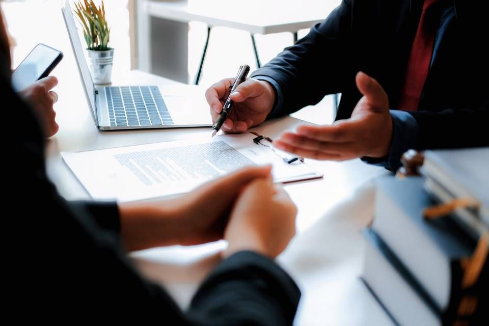Rechtsanwalt Bernd Scheske - Ein Mann und eine Frau sitzen mit einem Laptop an einem Tisch.