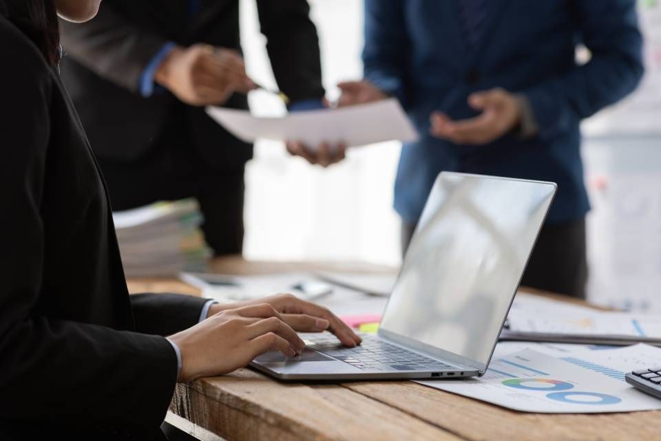 Rechtsanwalt Bernd Scheske - Eine Frau tippt auf einem Laptop, während ein Mann ein Blatt Papier hält.