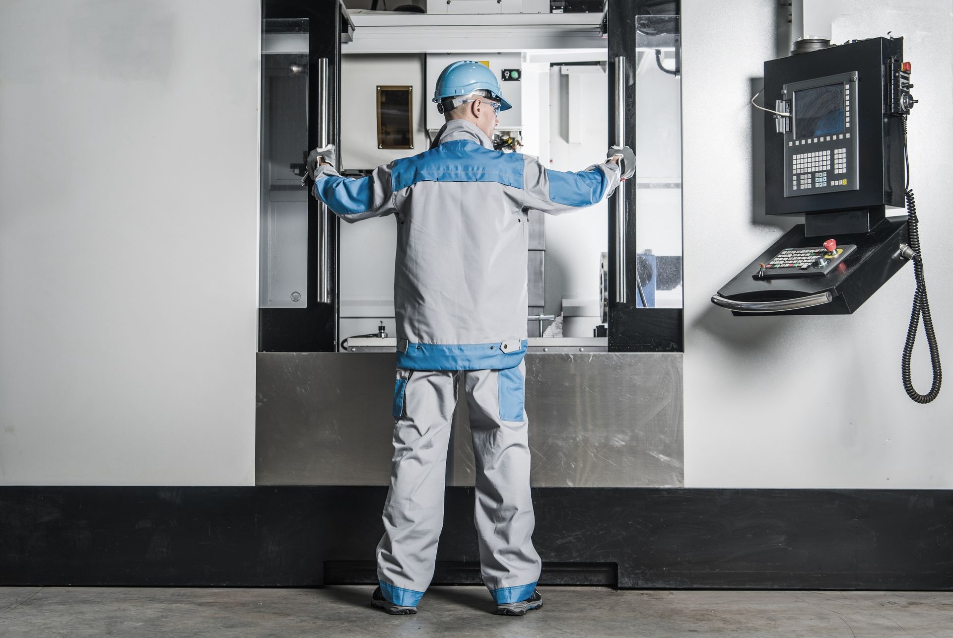 Ein Mann steht vor einer Maschine in einer Fabrik.