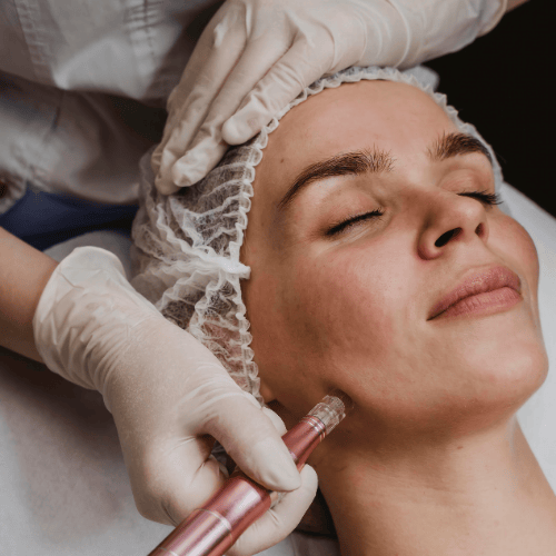 Mujer recibiendo un tratamiento cosmético para la piel en su rostro mientras está acostada.