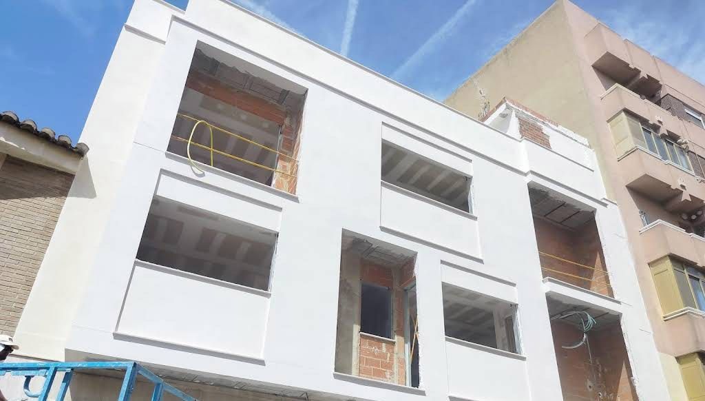 Interior de una habitación en construcción, con estructura de madera a la vista, grandes ventanales.