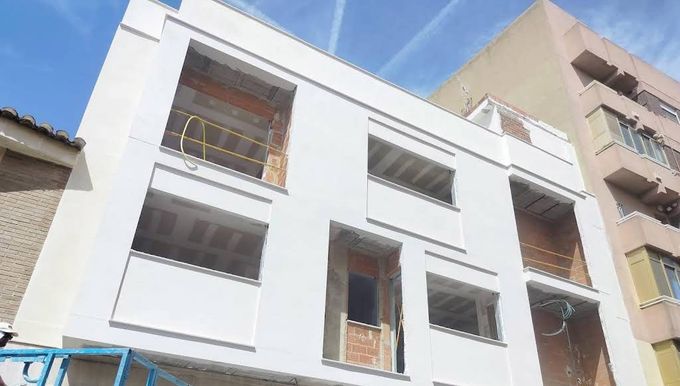 Interior de una habitación en construcción, con estructura de madera a la vista, grandes ventanales.