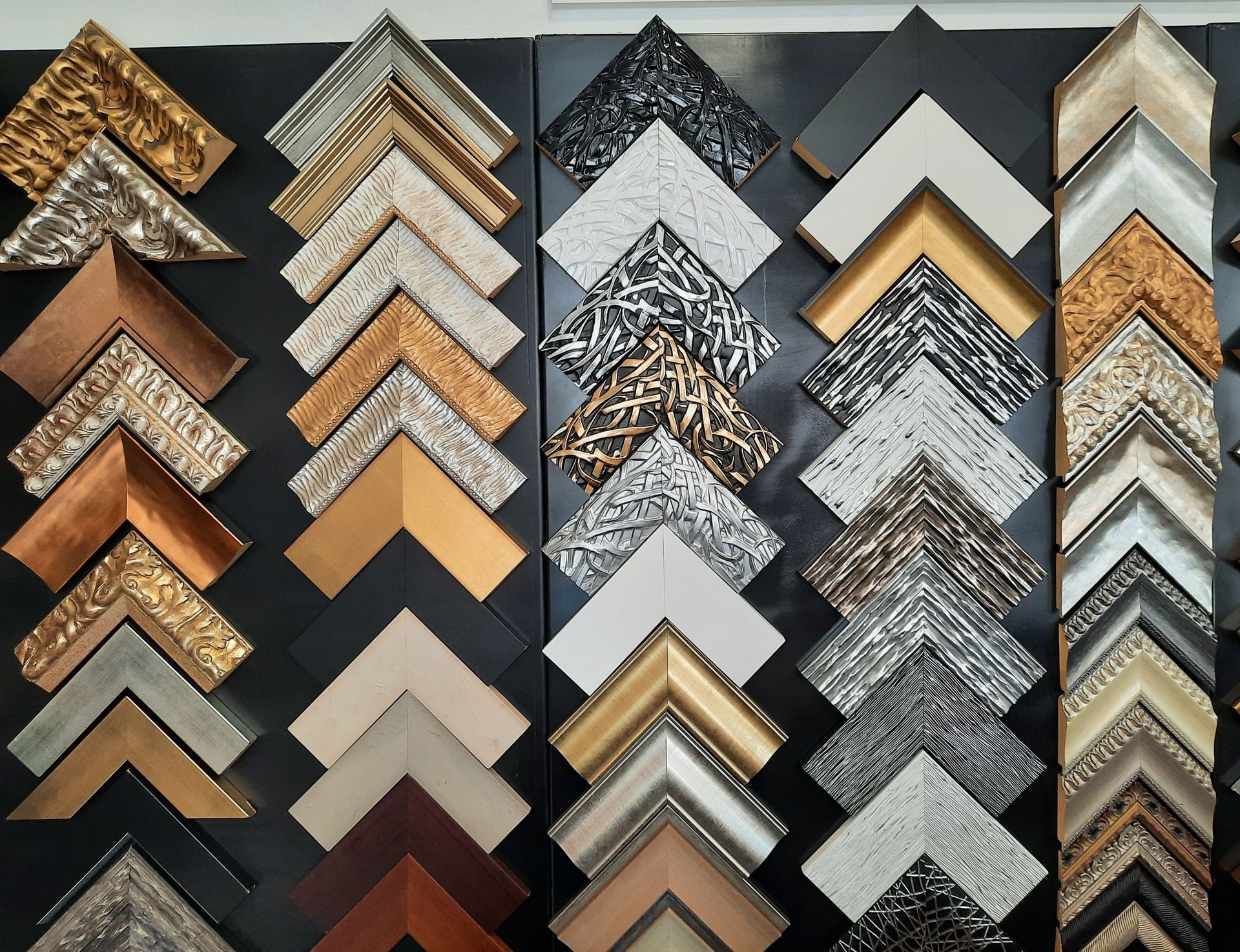 Uma variedade de molduras de fotos estão alinhadas em uma parede