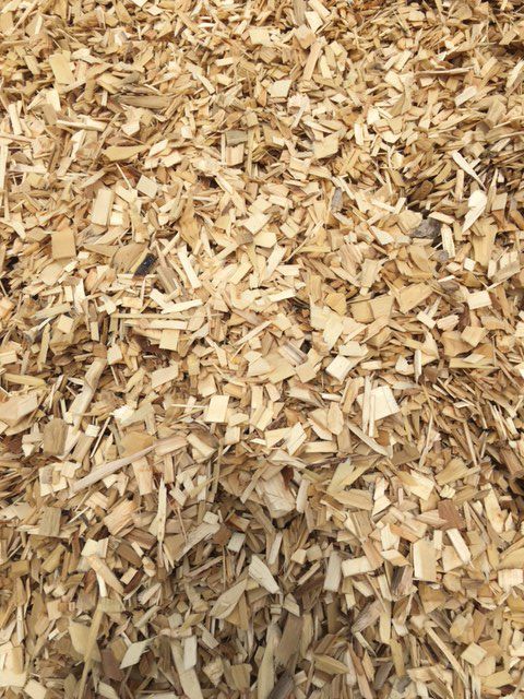 Tas de copeaux de bois clairs, convenant à l'aménagement paysager ou au jardinage.