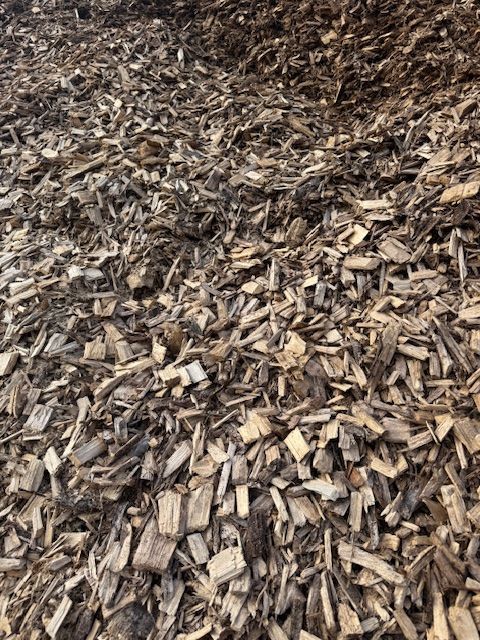 Tas de copeaux de bois, de différentes nuances de brun et de beige, densément tassés.