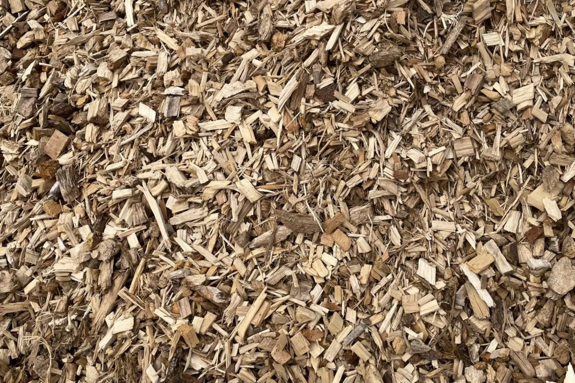 Gros plan sur des copeaux de bois bruns, adaptés à l'aménagement paysager ou au jardinage, dispersés.