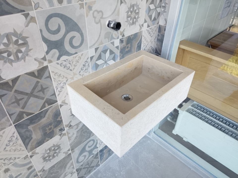 Ein Badezimmer mit Waschbecken und Fliesen an der Wand