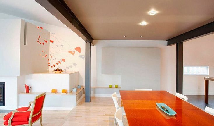 Un comedor con una mesa larga y sillas y una chimenea.