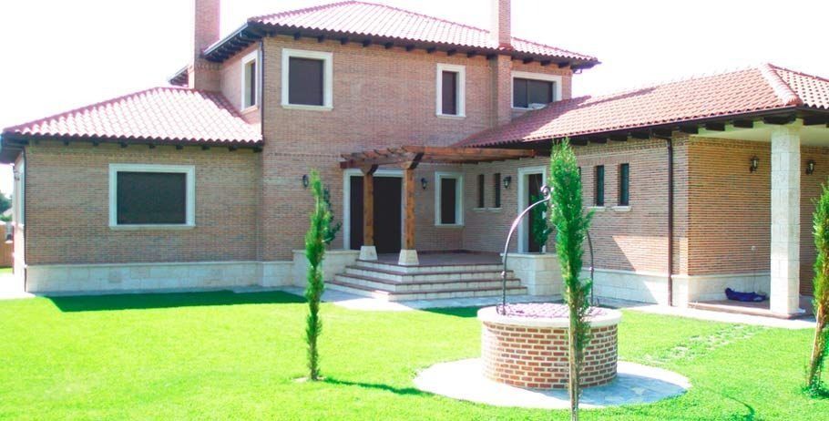 Una gran casa de ladrillo con techo de tejas rojas