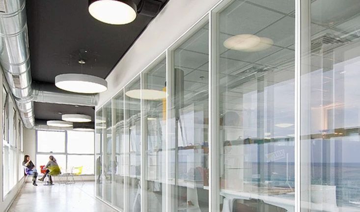 Un pasillo con muchas ventanas y gente caminando por él.