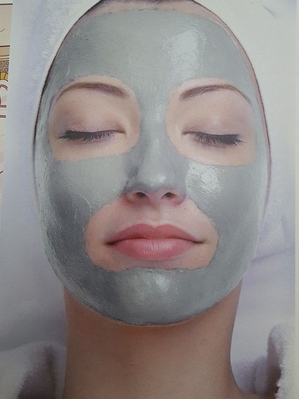 Una mujer lleva una mascarilla de arcilla en la cara.