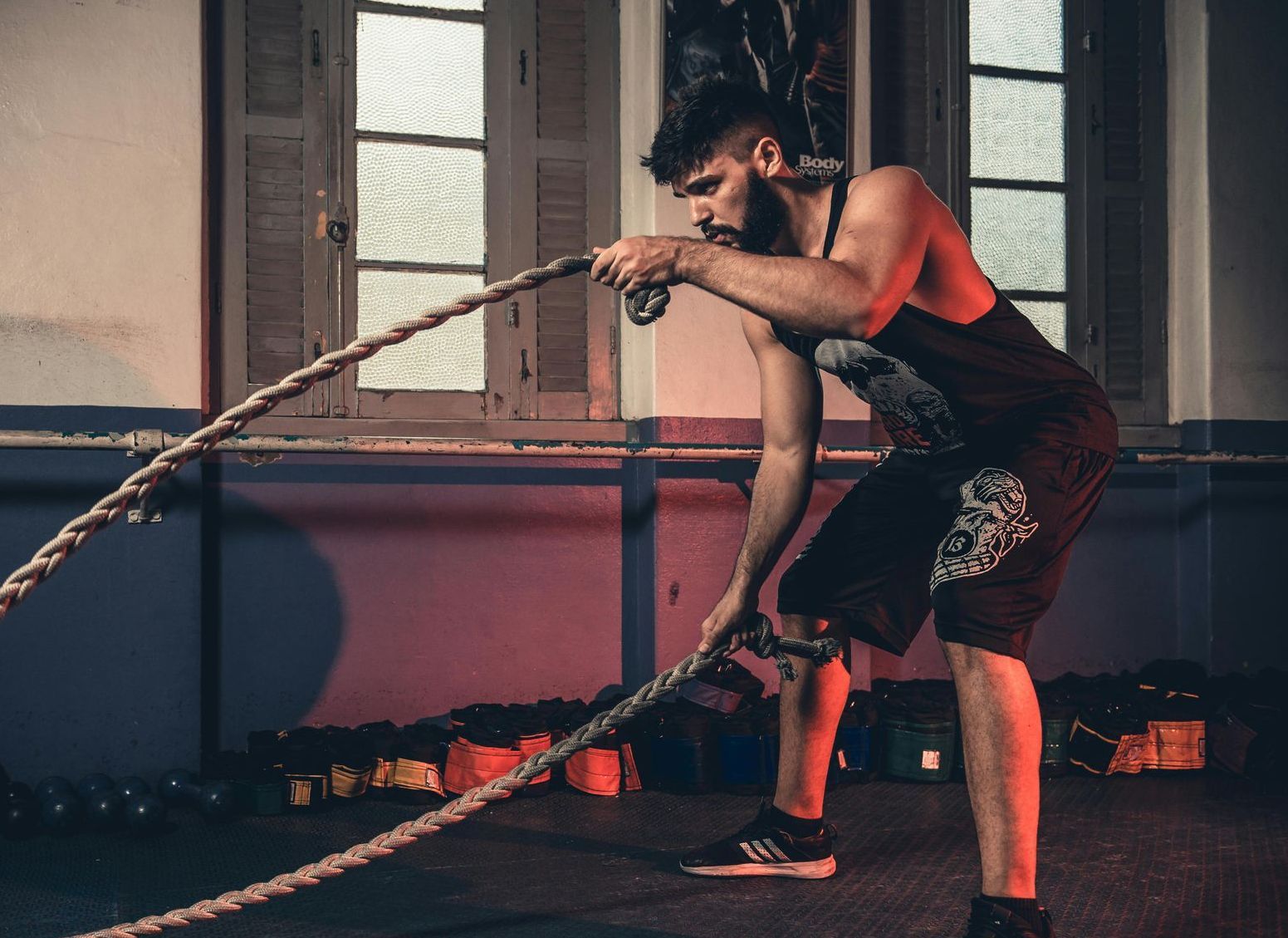 Um homem está segurando uma corda em uma academia.