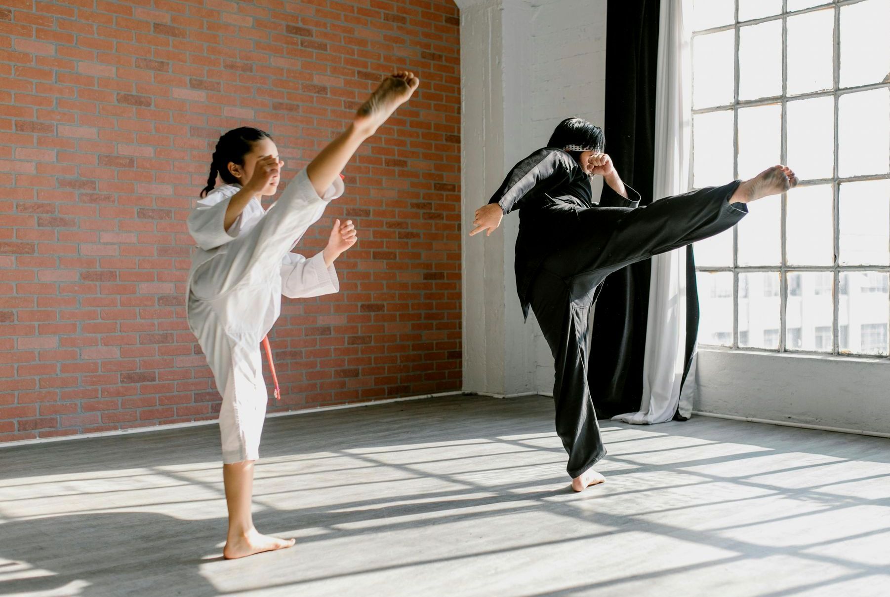 Um homem e uma mulher estão praticando caratê em uma academia.