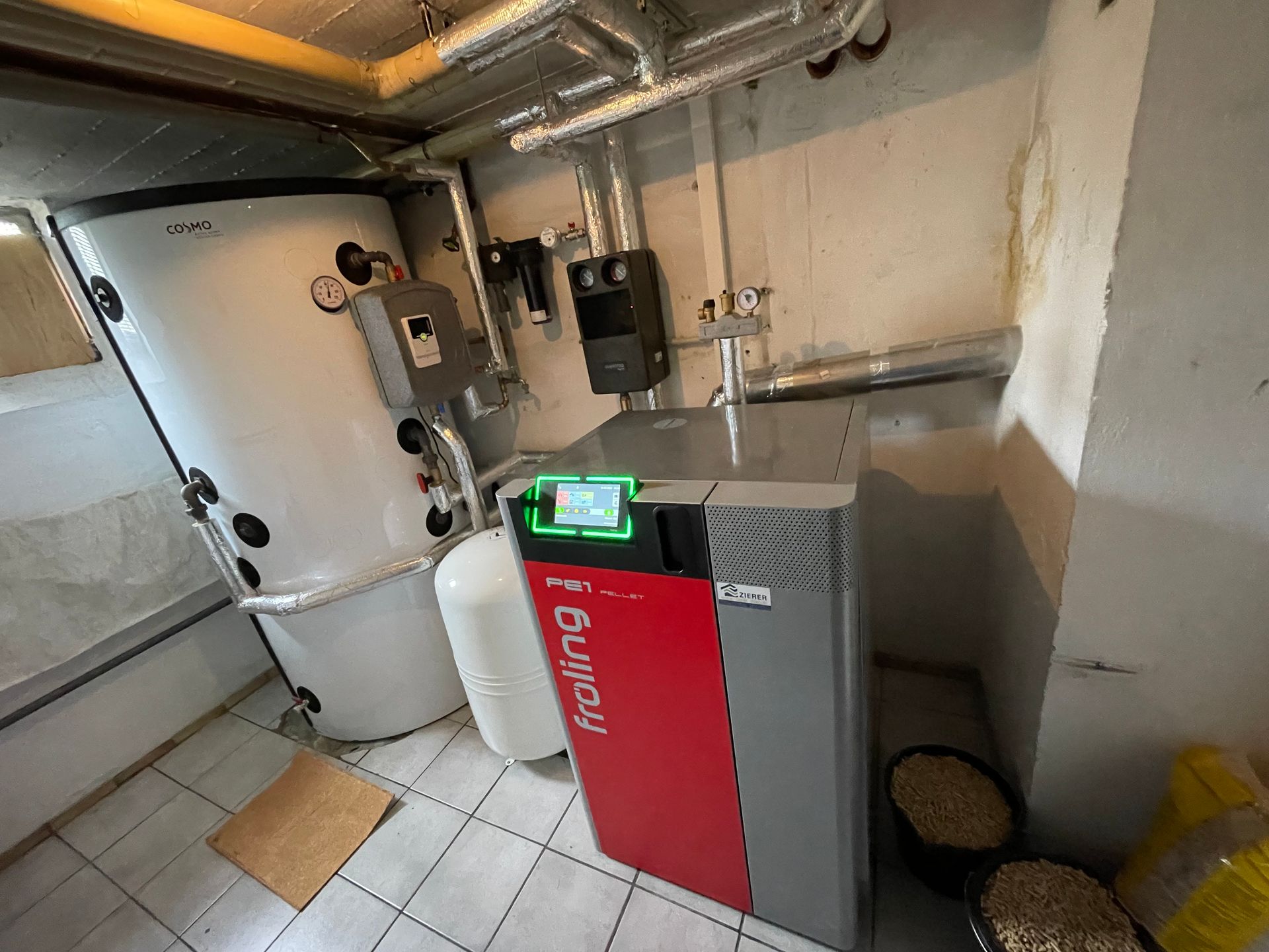 Ein fröling PE1 Pelletkessel steht in einem Heizungsraum