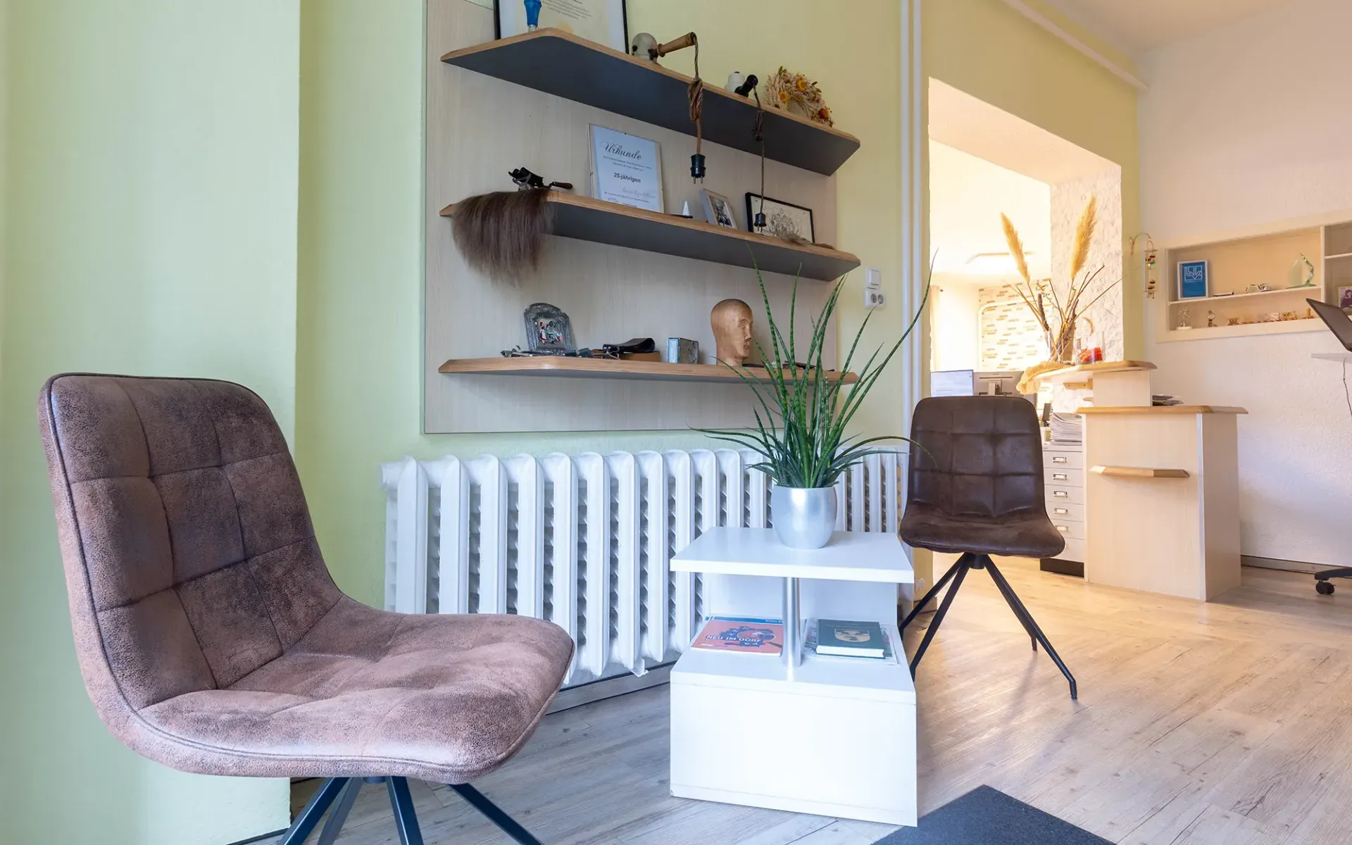 Ein Wohnzimmer mit zwei Stühlen, einem Tisch und einem Heizkörper.