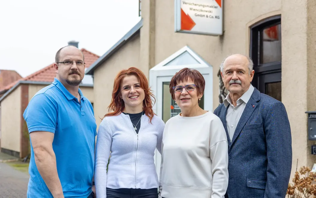 Eine Gruppe von Menschen posiert vor einem Gebäude für ein Foto.
