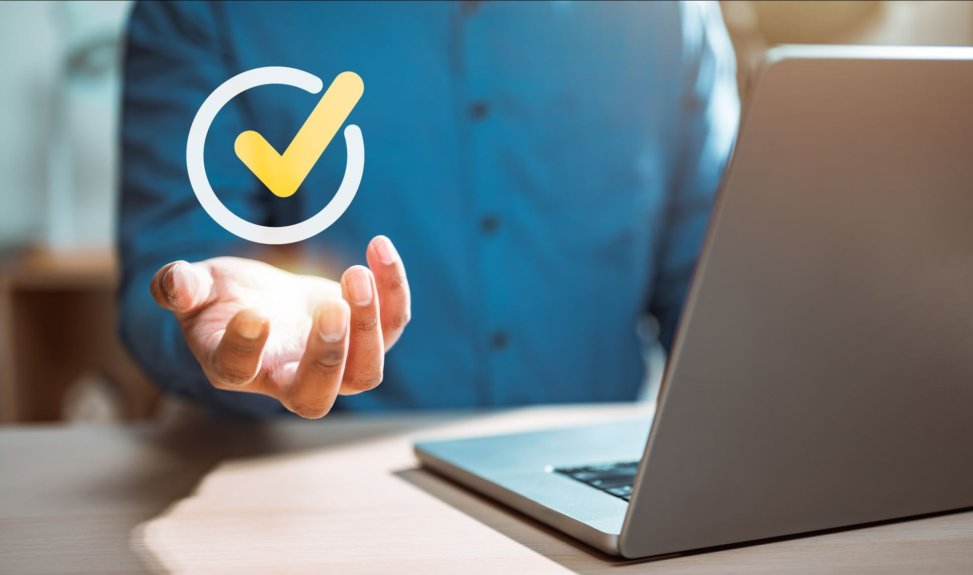 Coche de validation jaune en suspension au-dessus d'une main d'homme en chemise bleue