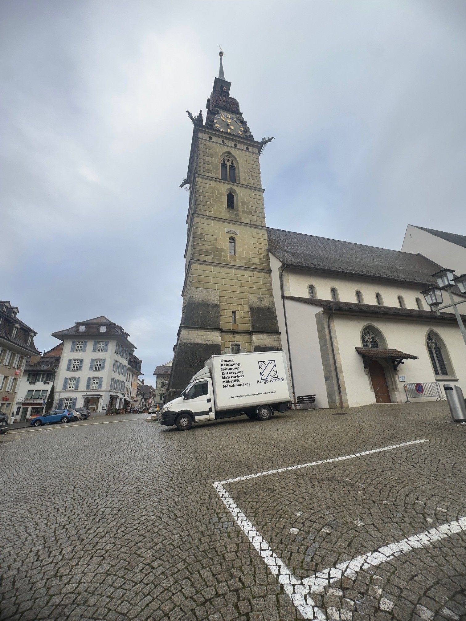 Historische Kirche mit Spitzturm, bewölkter Himmel