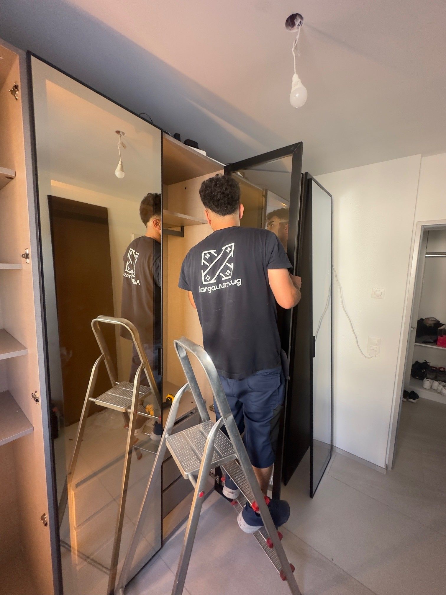 Umzugshelfer in Arbeitskleidung in heller moderner Wohnung