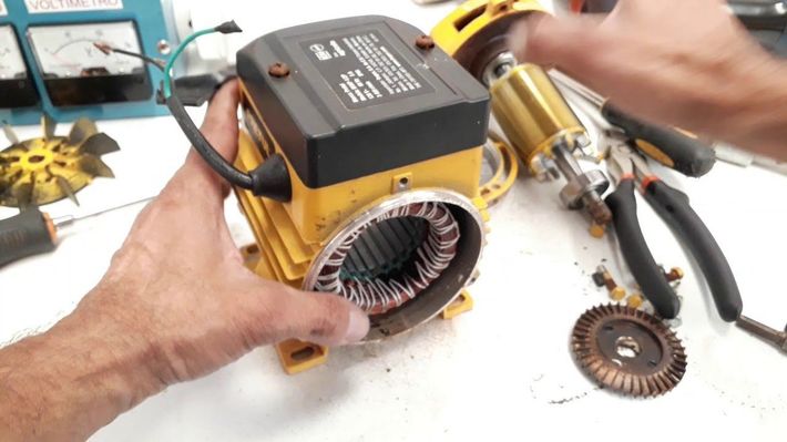 Una persona está trabajando en un motor sobre una mesa.