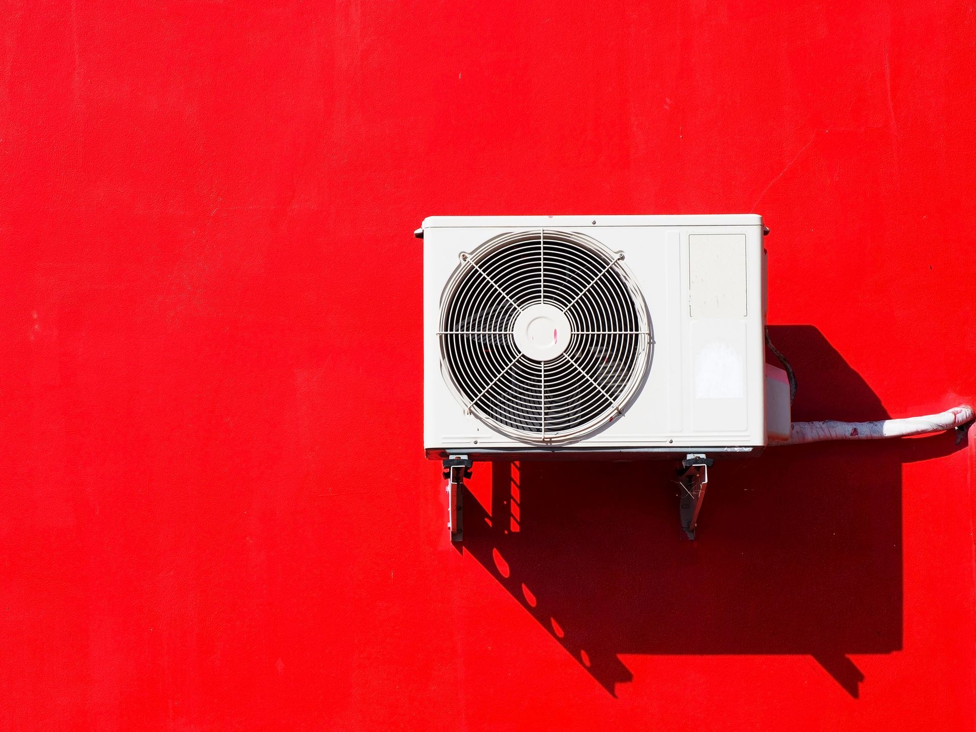 Une pompe à chaleur sur un mur rouge
