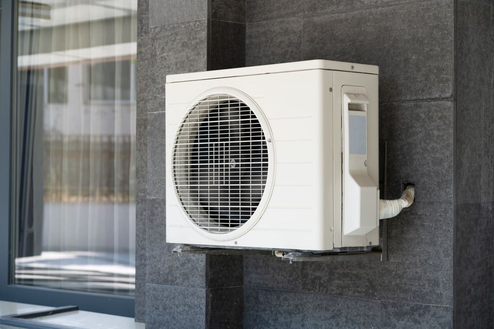 Une pompe à chaleur sur un mur gris