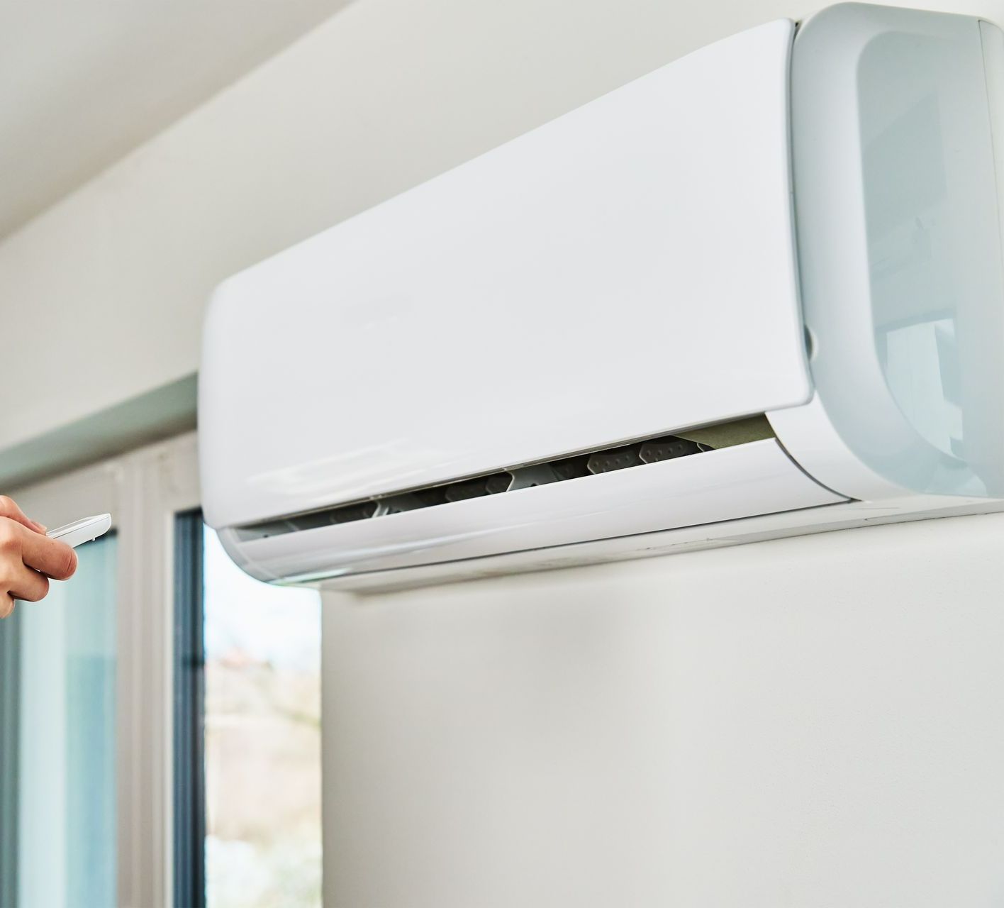 Une personne qui allume la climatisation