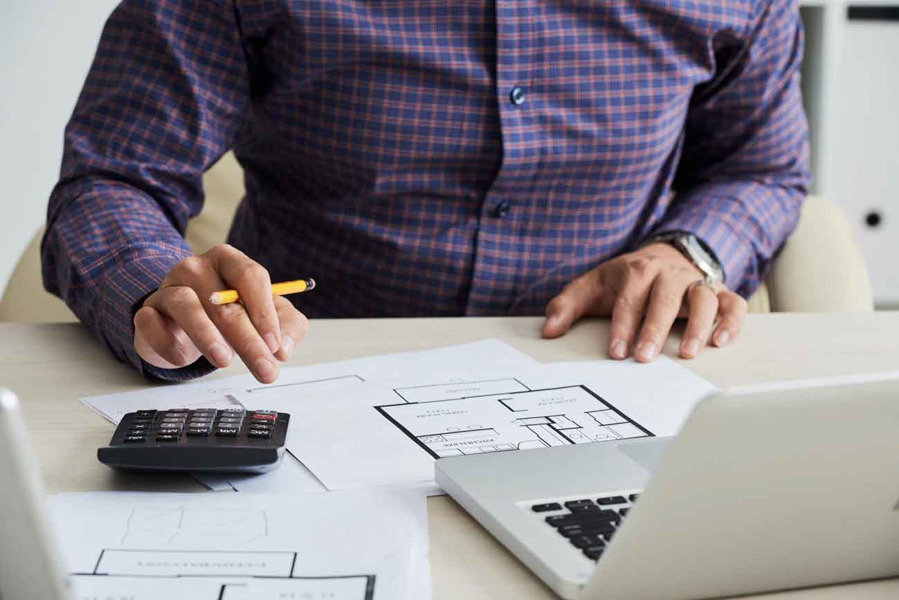 Un homme à la chemise à carreaux utilisant une calculette