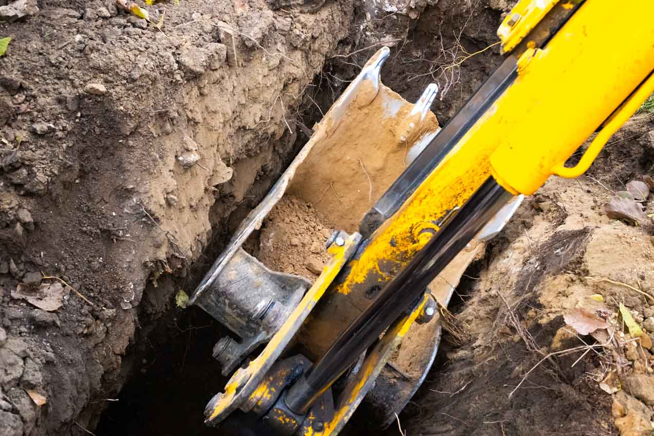 Pelleteuse creusant dans la terre d'un terrain