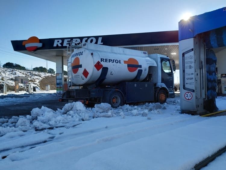 Camión cisterna de combustible en gasolinera Repsol en condiciones de nieve.