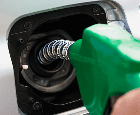 Boquilla de combustible verde que llena el tanque de gasolina del automóvil.