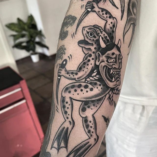 Una persona tiene un tatuaje de una rana con cuernos en el brazo.