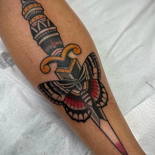 Un tatuaje de una daga con una mariposa en ella.