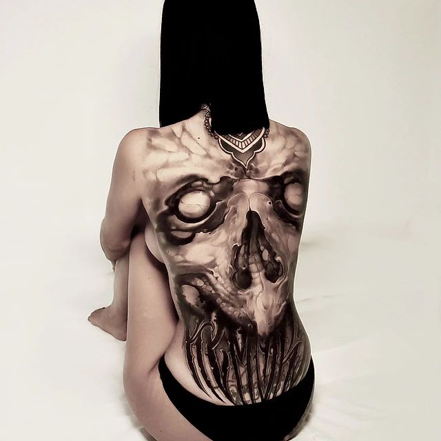 Una mujer con un tatuaje de calavera en la espalda