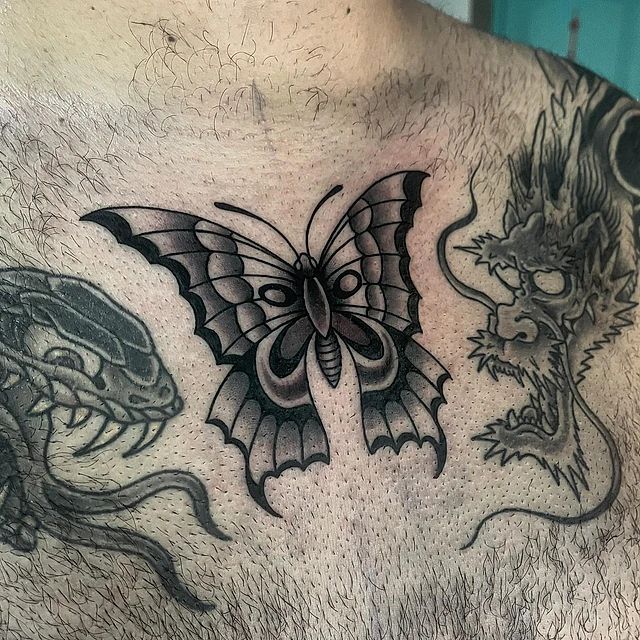 Un hombre tiene un tatuaje de una mariposa y un dragón en el pecho.