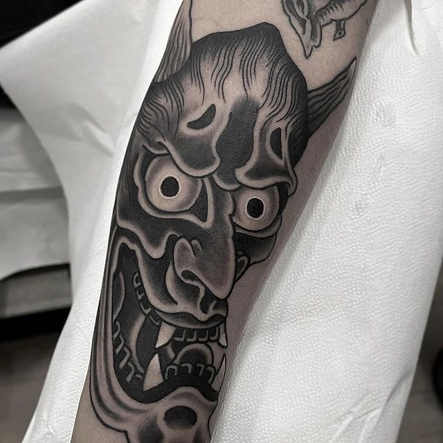 Una persona tiene un tatuaje de un demonio en su brazo.