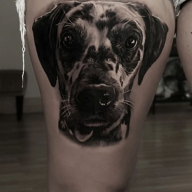 Una mujer tiene un tatuaje de un perro en la pierna.