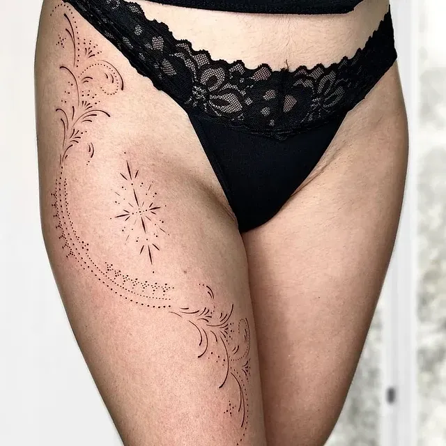 Una mujer en ropa interior negra tiene un tatuaje en la pierna.