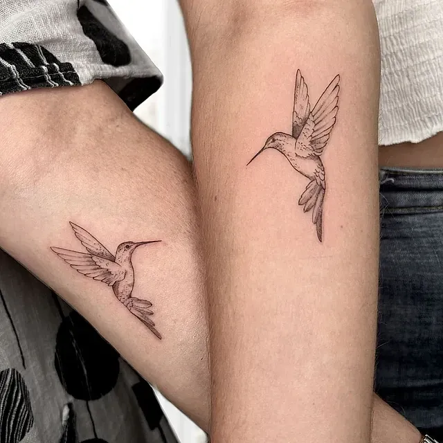 Dos colibríes tatuados en el antebrazo de una persona