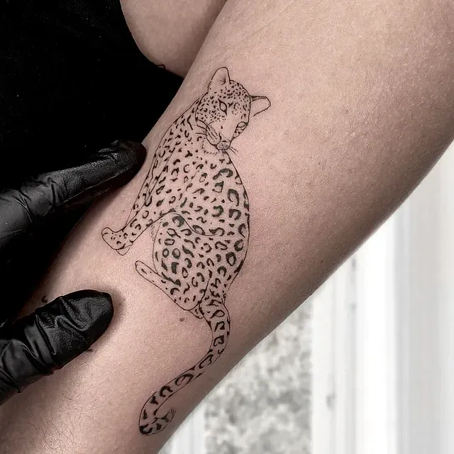 Una persona tiene un tatuaje de un leopardo en el brazo.