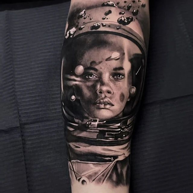 Un tatuaje en blanco y negro de una mujer con un casco de astronauta.