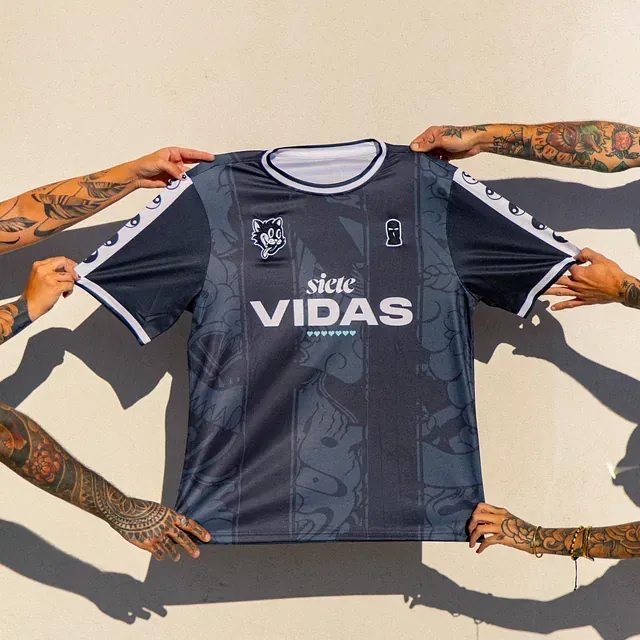 Un grupo de personas sosteniendo una camiseta que dice siete vidas